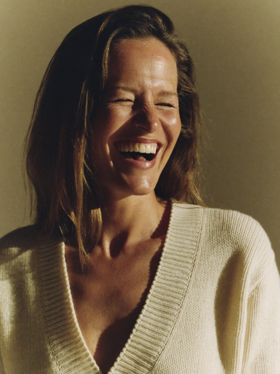 Woman with a wide smile in ivory sweater